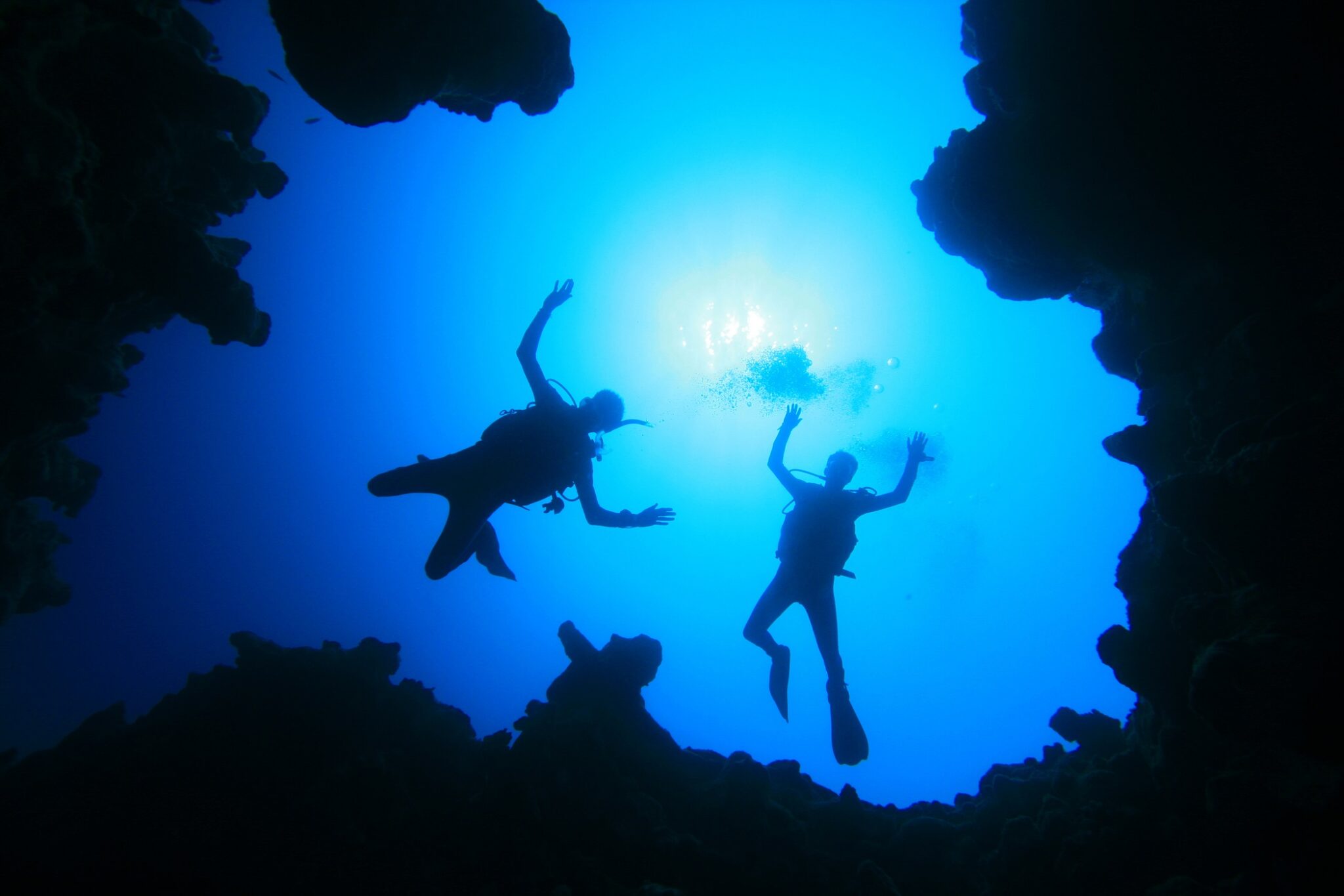 two scuba divers descend from above