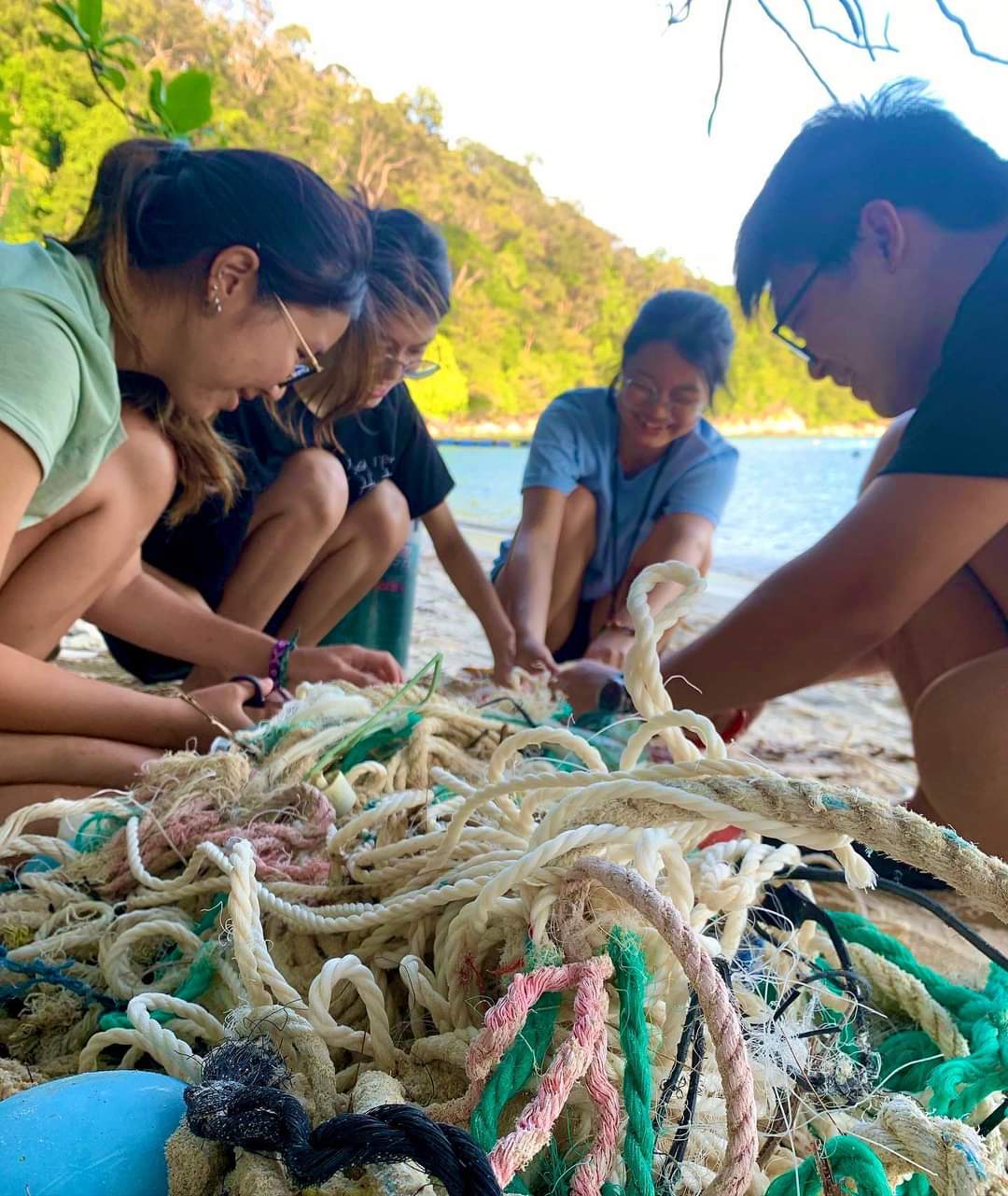 A group of people cut up a tangle of ropes and fishing nets