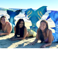Elle Jimenez, Elaina Thomas, and Great Chin Burger posing on a beach