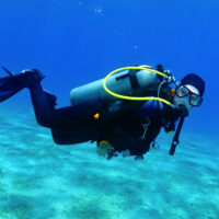 a scuba diver underwater looking directly at the camera