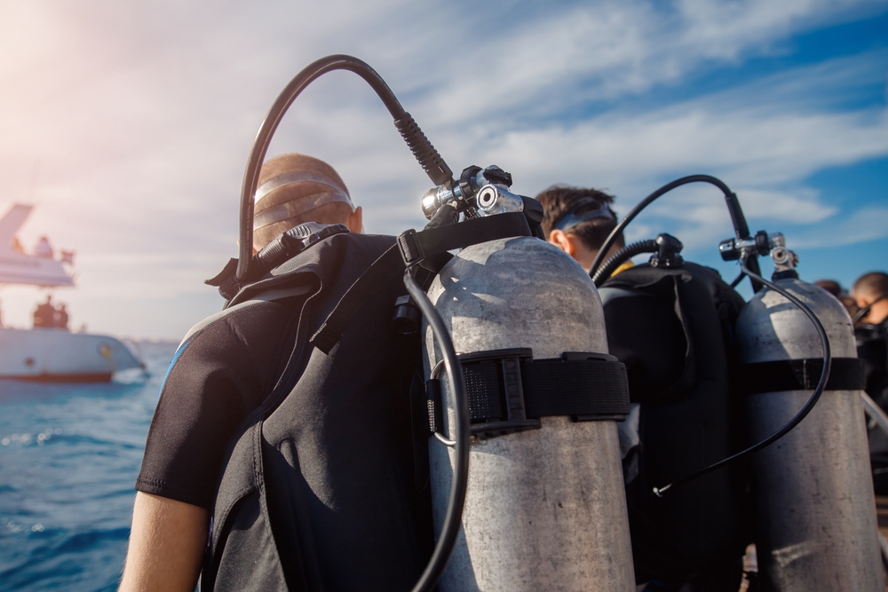 two divers sitting on a boat ready to dive give the gift of exploration