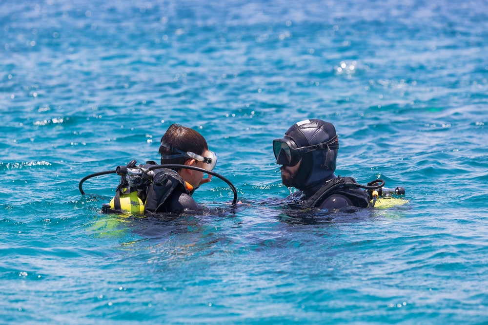two scuba divers at the su