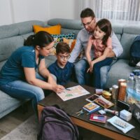 Mother explaining to her family the assembly point map while preparing emergency backpacks