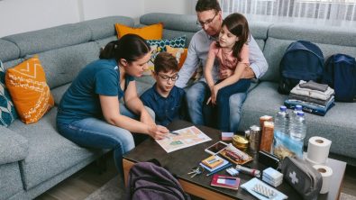 Mother explaining to her family the assembly point map while preparing emergency backpacks