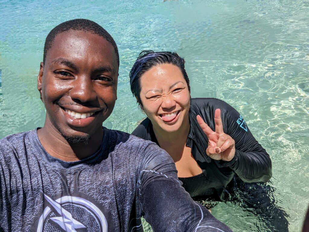 Two divers smile in clear water near Sandals Resorts.