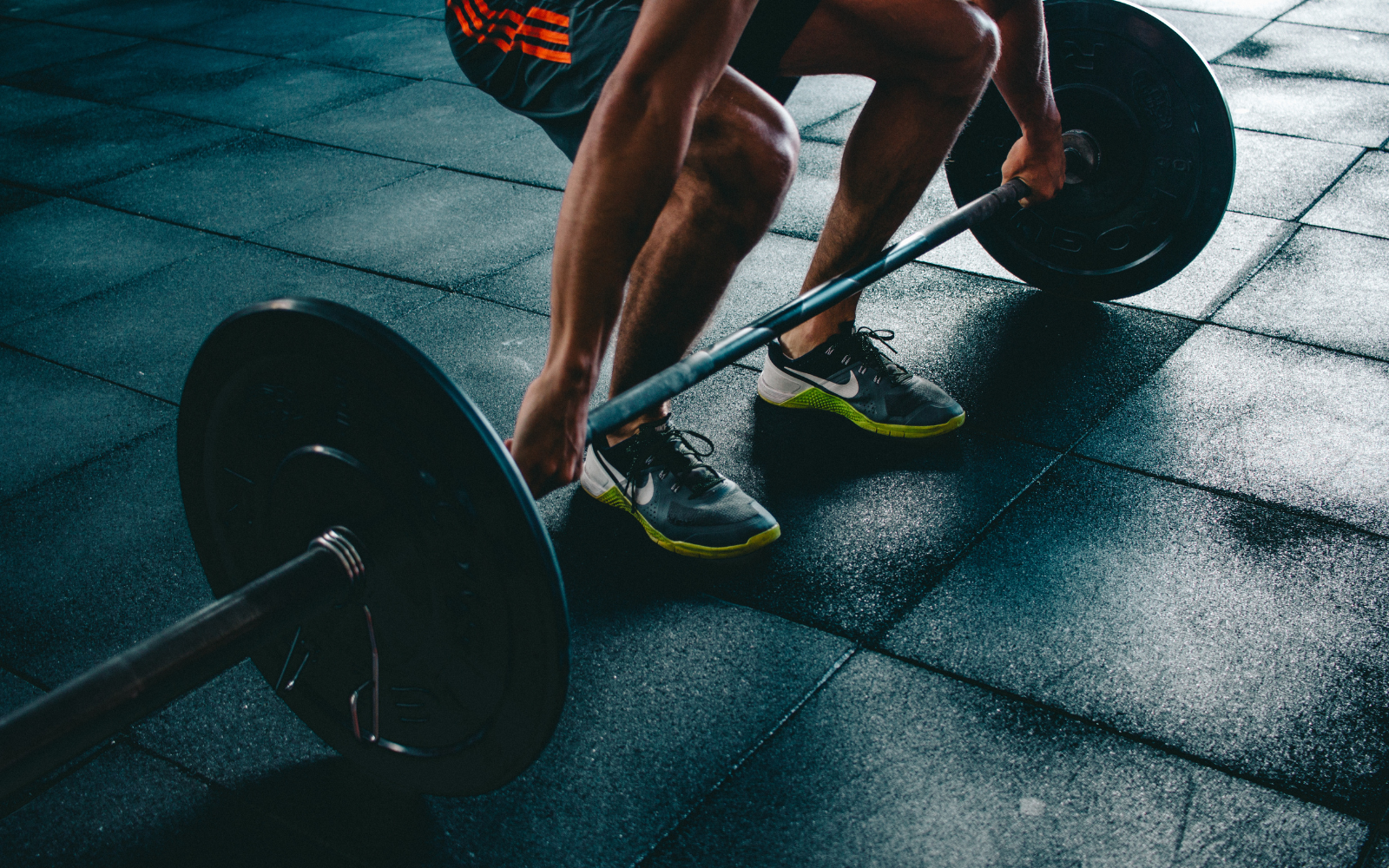 A person lifts weights at the gym which is an example of what not to do after scuba diving along with other types of exercise