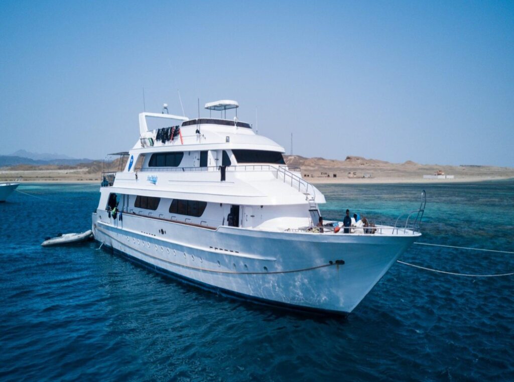 Scuba liveaboard boat Blue Melody in the Red Sea with a desert landscape in the background