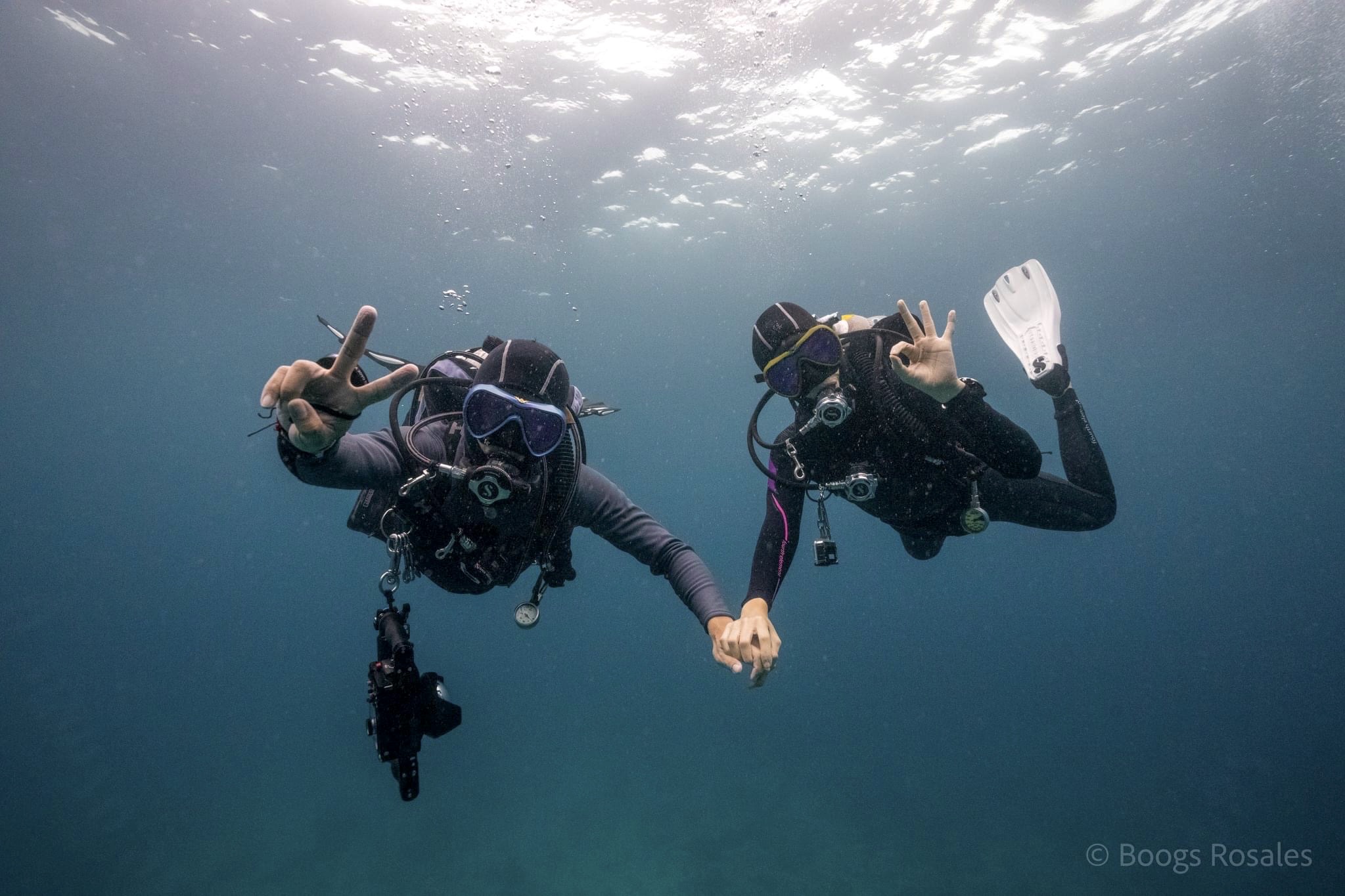 Newly engaged scuba couple Gage Veridiano and Joanne Villablanca holding hands and making connections together underwater