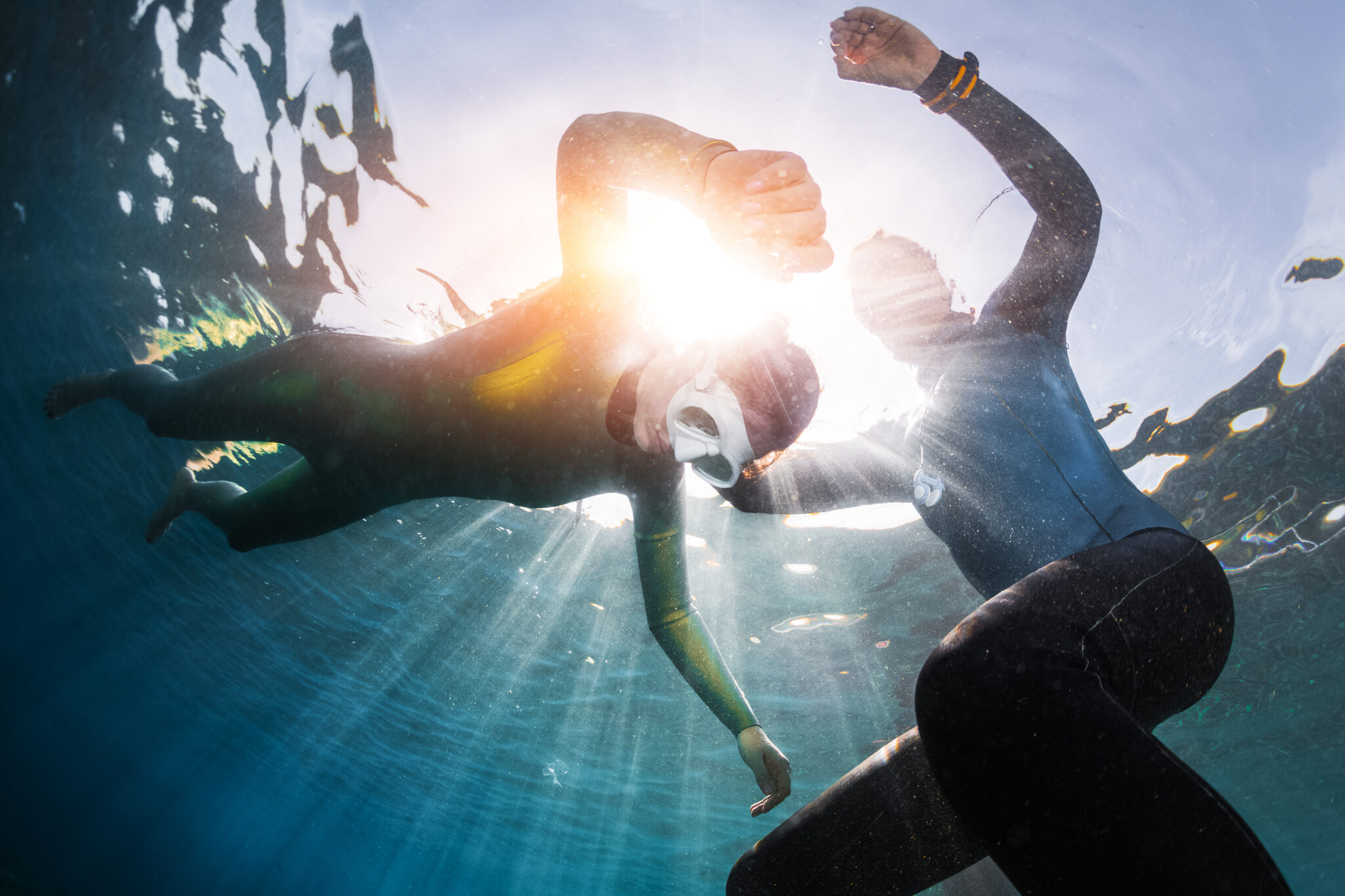 a diver practices static apnea breath hold freediving in shallow water with a trained buddy