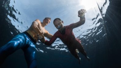a diver practices static apnea breath hold freediving in shallow water with a trained buddy