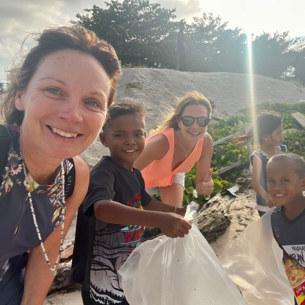 two women and a child partake in a beach clean-up in Borneo