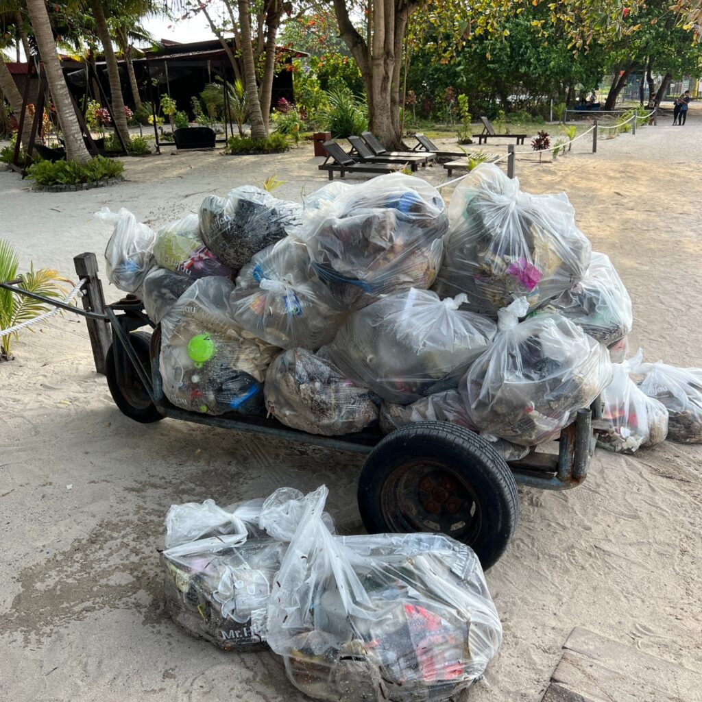 A bunch of garbage bags on a cart on a be3ach in Borneo