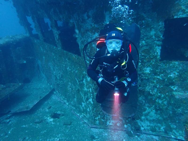 A young scuba diver explores a wreck in Australia