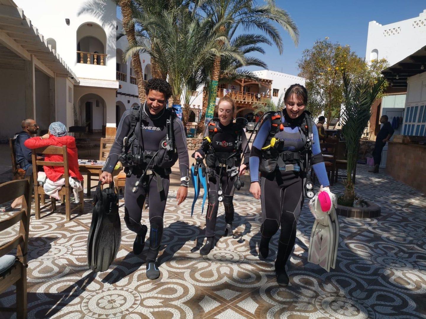 three divers walk through the resort at desert divers dahab egypt