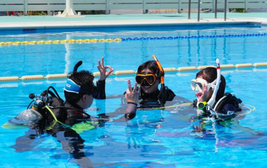 Students learning scuba diving skills in confined water during a PADI Open Water Diver course