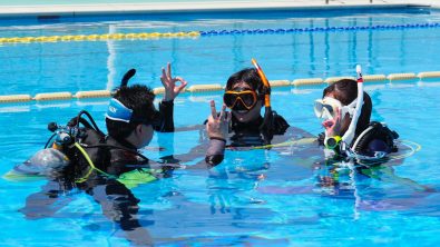 Students learning scuba diving skills in confined water during a PADI Open Water Diver course