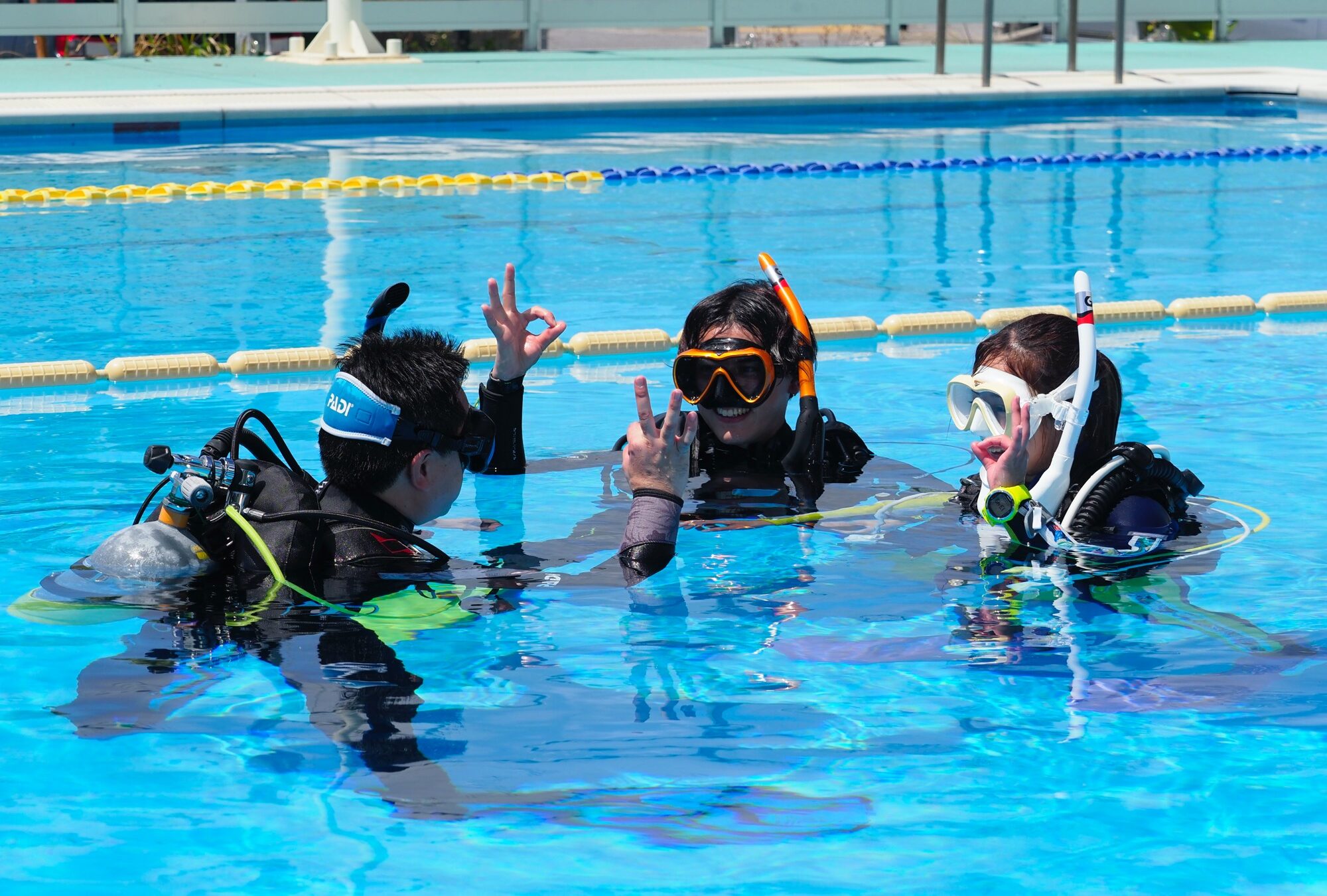 Students learning scuba diving skills in confined water during a PADI Open Water Diver course
