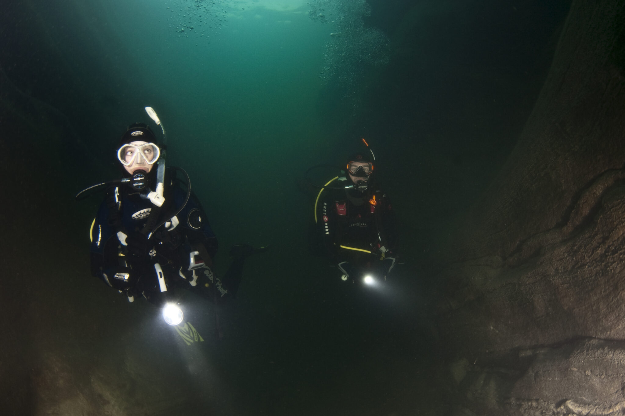 two PADI Deep Divers explore the underwater world with flashlights