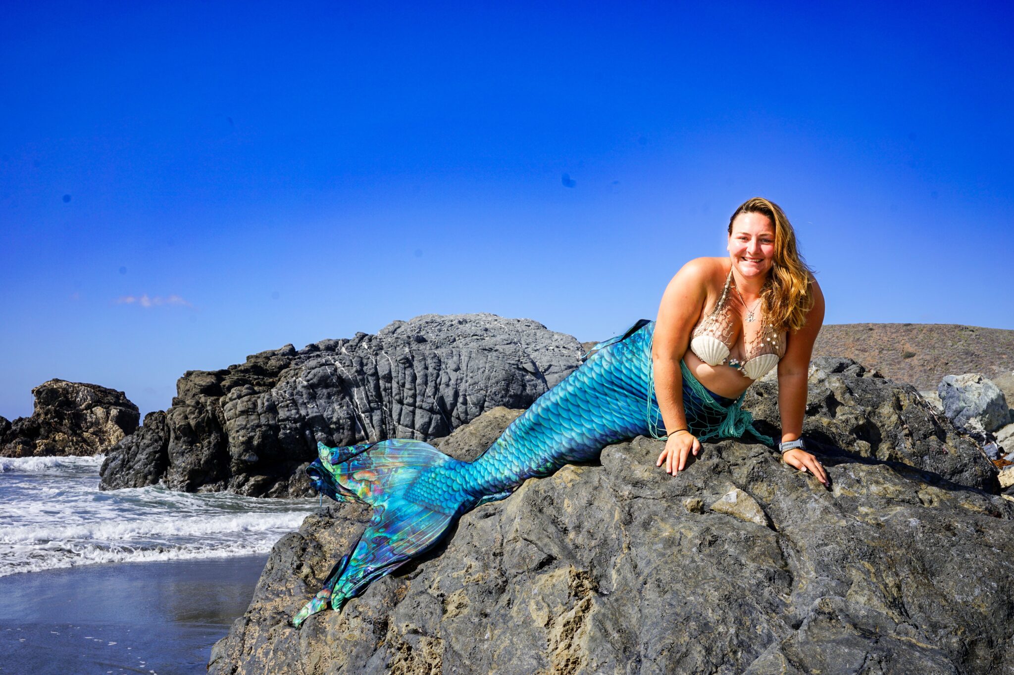 Pro Mermaid Elaina Thomas from @catalinaislandmermaids on a rock