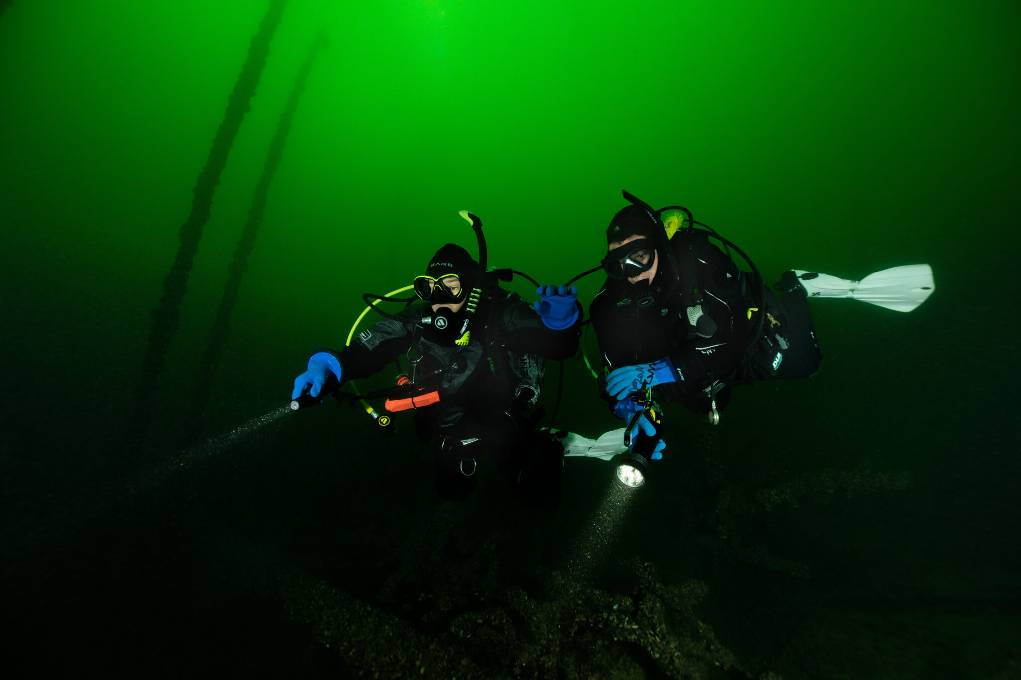 two padi underwater navigators explore the underwater world in Germany with flashlights