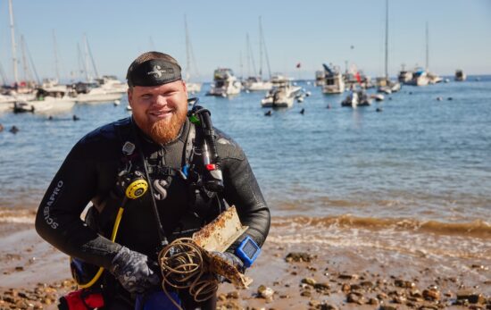 A diver exits the water with garbage found during a dive off Catalina Island, California