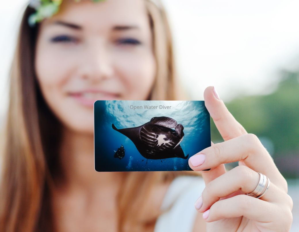 a woman holds a mana ray padi certification card