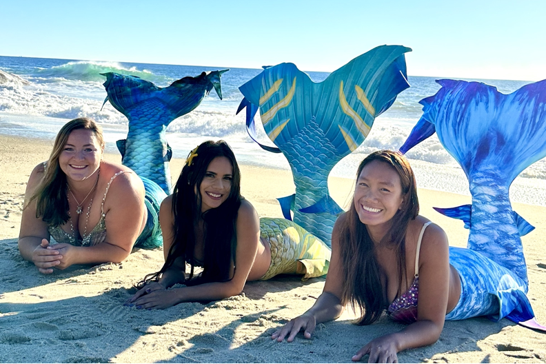 Elle Jimenez, Elaina Thomas, and Great Chin Burger posing on a beach