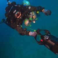 a technical diver uses a dpv to glide through deep water