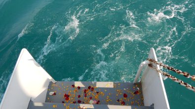 Flower petals scattered down the back steps of a boat loading to the ocean for a memorial