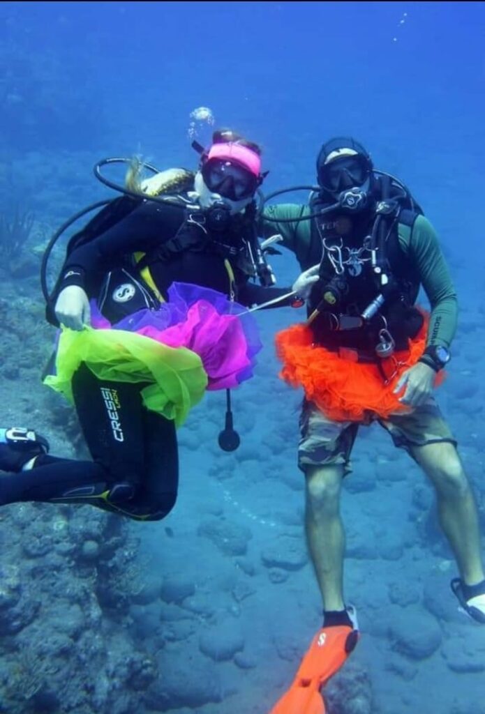Two divers wear fluorescent tutus while diving in Saba.