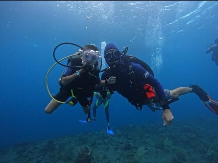 A father and son dive together in Saba.