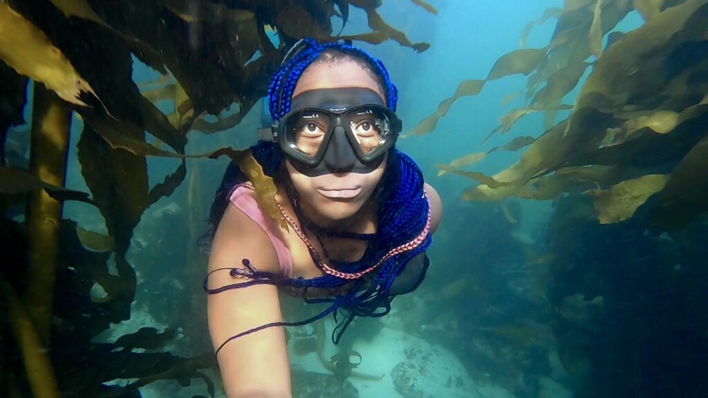 PADI AmbassaDiver Zandile Ndhlovu freedives through a kelp forest in South Africa