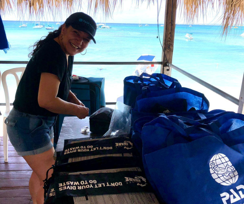 a woman is looking at bags of conservation materials in a cabana by the ocean