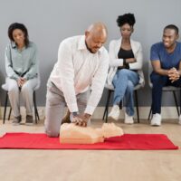 A group of students practice cpr on a dummy