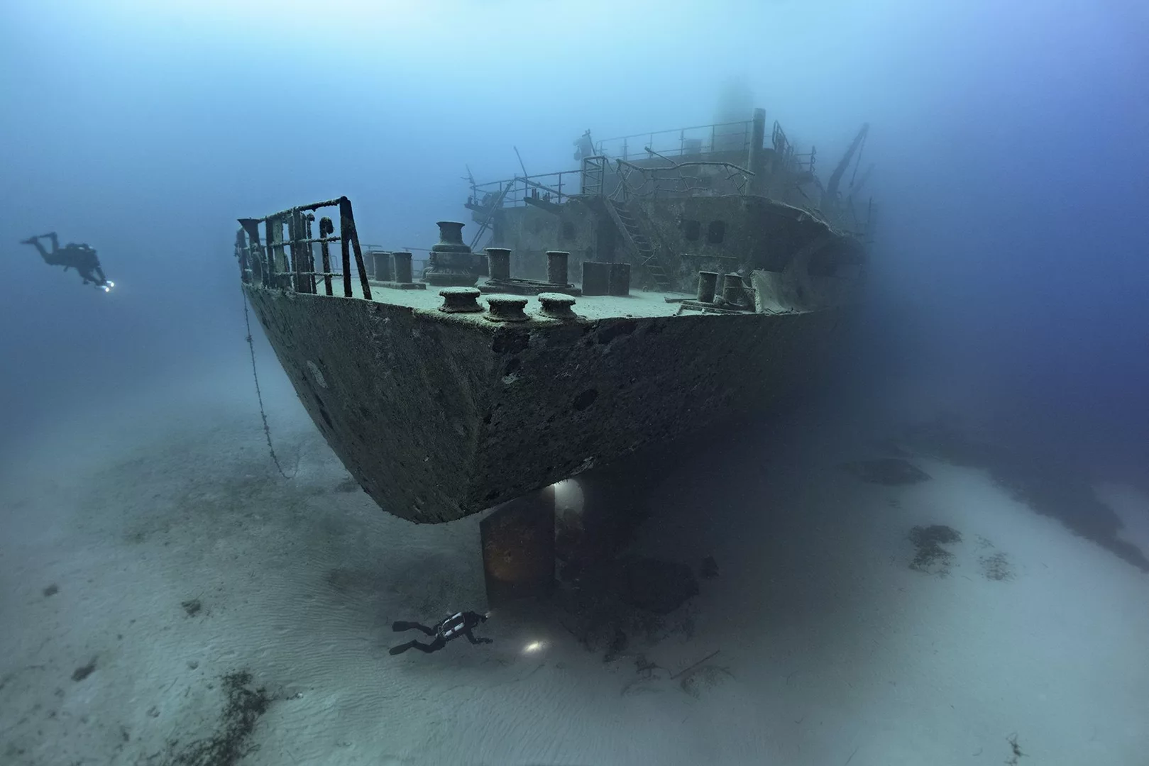 Divers exploring the Um El Faroud, which marks 25 Years in 2023 as one of the top shipwrecks and best places to dive in Malta