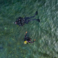 two divers learn to dive at home. This is the two divers in the water shot from a drone above them