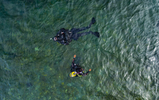 two divers learn to dive at home. This is the two divers in the water shot from a drone above them