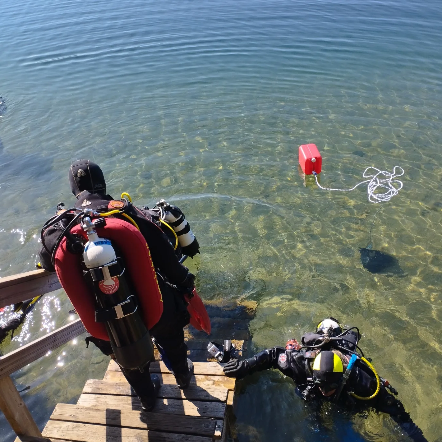 A diver heads down a wooden staircase to clear Finnish waters