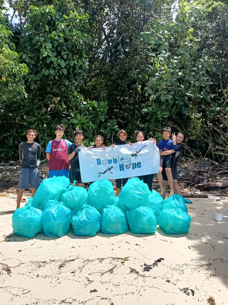 volunteers with a banner and trash dive with padi eco center