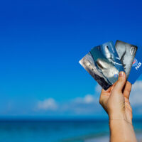 A hand holds up four PADI certification cards