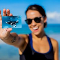 A female diver holding up a certification with a manta on it