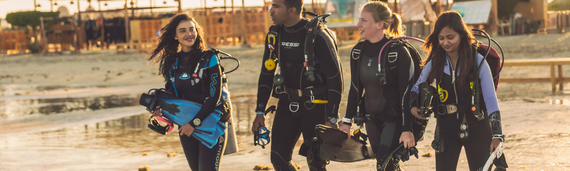 four divers enter the water together in the red sea, egypt
