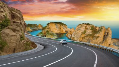 highway landscape at colorful sunset. road view on mediterranean coast of spain. coastal road landscape beautiful nature scenery. car driving on mountain road by the sea. summer vacation on the beach.