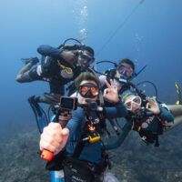 A group of scuba divers take a selfie with a gopro