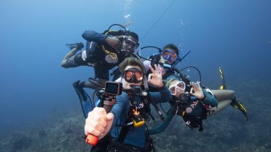 A group of scuba divers take a selfie with a gopro