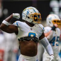 An NFL player reacts to a good play during a game with his arm raised in celebration.