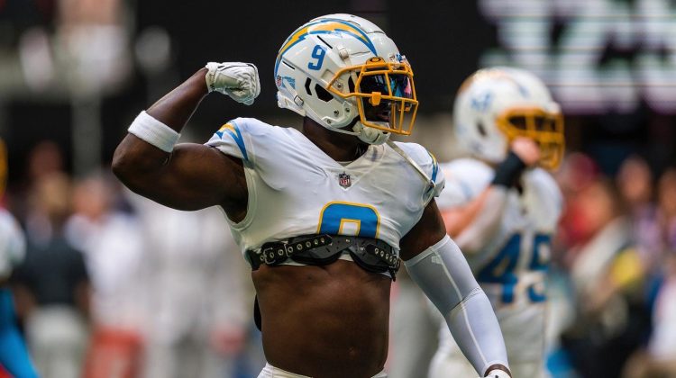 An NFL player reacts to a good play during a game with his arm raised in celebration.
