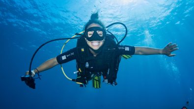 Enjoy a gift of experience - Woman diver smiling at the camera underwater