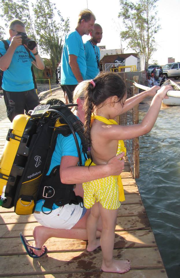 diver holding a child next to the water