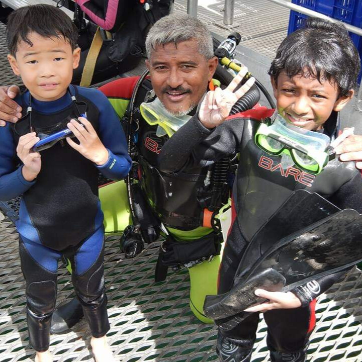 Syed Abd Raman poses with two children, who are student divers and snorkelers